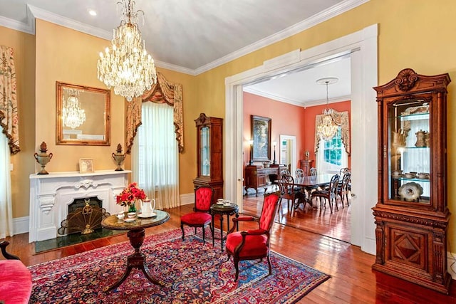 living area with an inviting chandelier, wood-type flooring, and ornamental molding