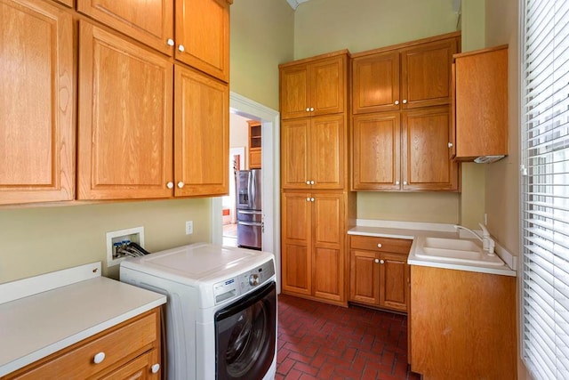 laundry room with sink, cabinets, and washer / dryer