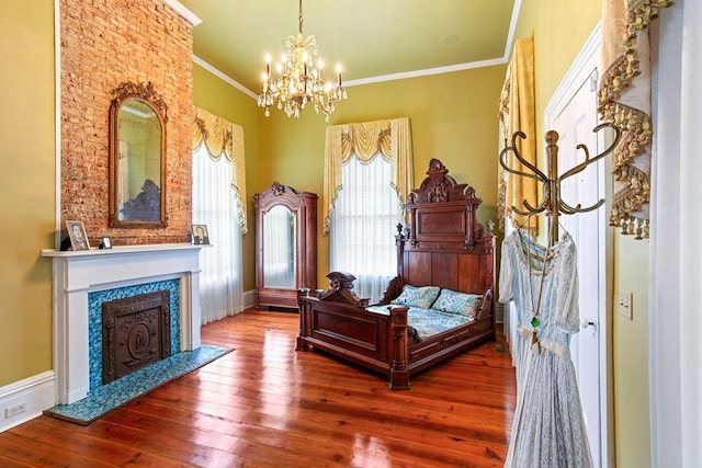 bedroom featuring a notable chandelier, wood-type flooring, crown molding, and a high end fireplace