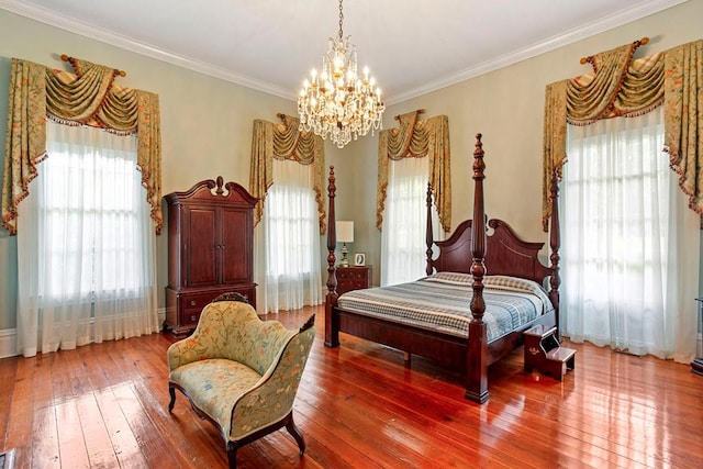 bedroom featuring hardwood / wood-style flooring, crown molding, and a chandelier