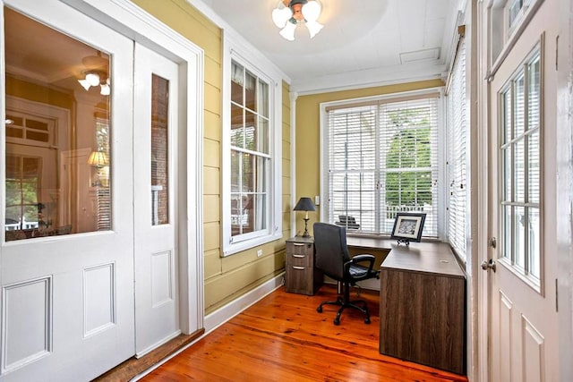 office featuring wood-type flooring, french doors, ornamental molding, and a notable chandelier