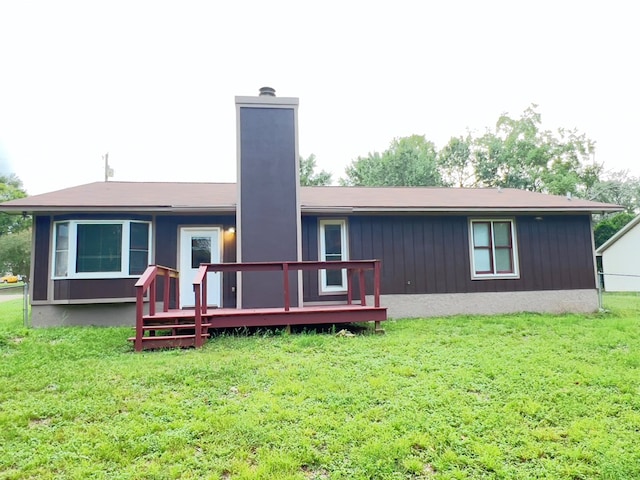 back of house featuring a wooden deck and a lawn