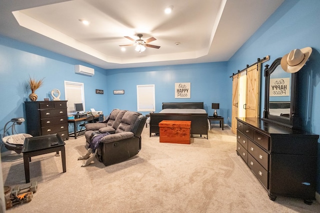 bedroom with light carpet, a barn door, a wall mounted air conditioner, and a raised ceiling