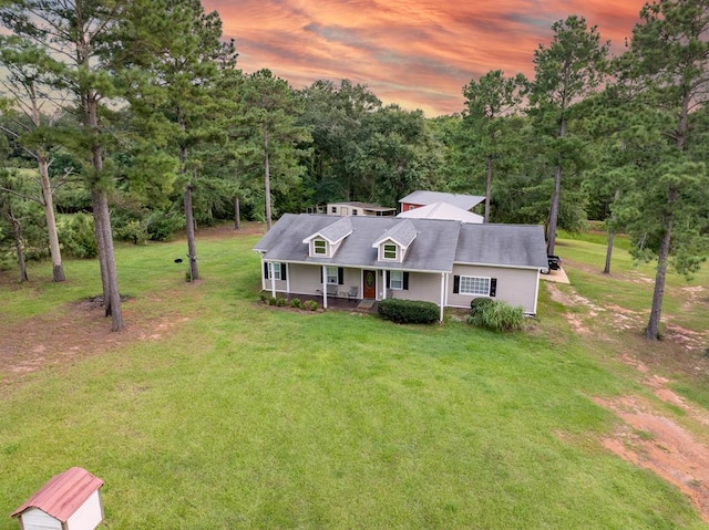 view of front of home with covered porch and a lawn