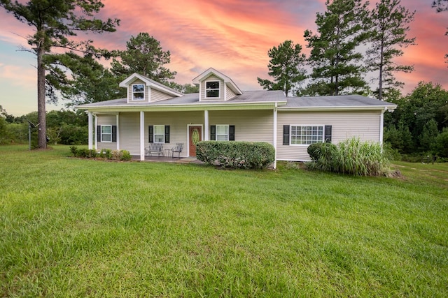 view of front of home featuring covered porch and a lawn