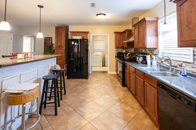 kitchen featuring sink, hanging light fixtures, backsplash, a breakfast bar area, and black appliances