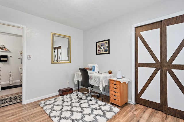 office with a textured ceiling and light wood-type flooring