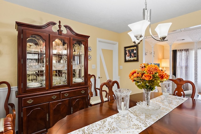 dining room with a textured ceiling and an inviting chandelier