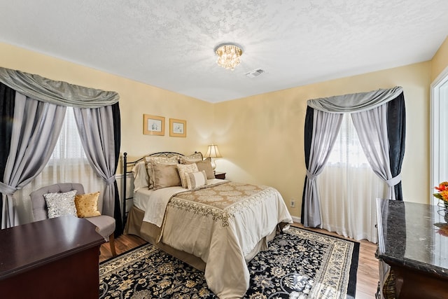 bedroom with a textured ceiling and light wood-type flooring