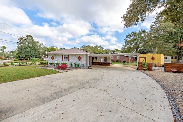 view of front facade featuring a front lawn, a carport, and an outdoor structure