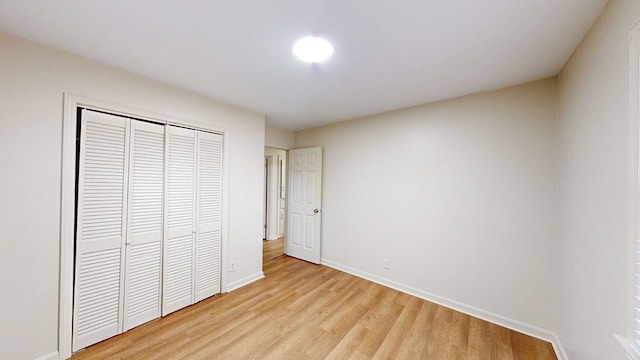 unfurnished bedroom featuring light hardwood / wood-style floors and a closet