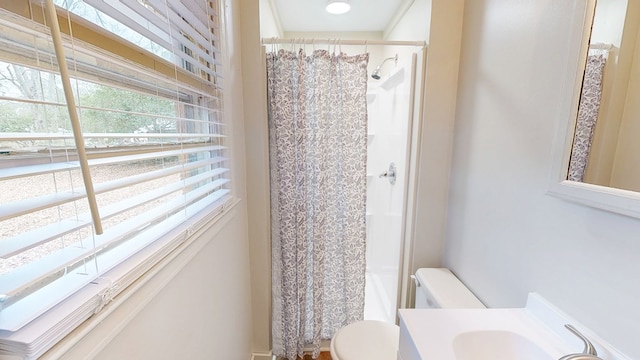 bathroom featuring sink, a shower with curtain, and toilet