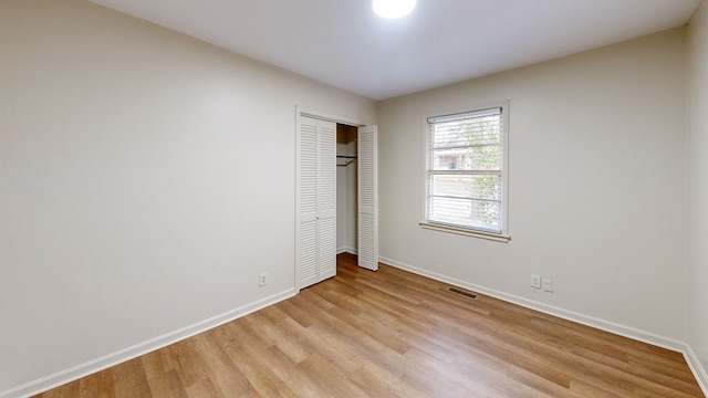 unfurnished bedroom featuring light wood-type flooring and a closet