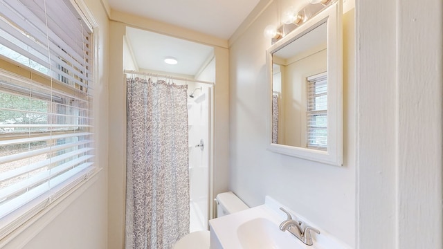 bathroom featuring sink, curtained shower, and toilet