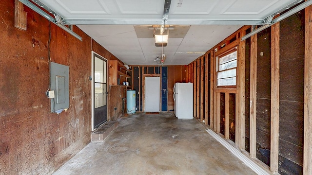 miscellaneous room featuring water heater, concrete flooring, and electric panel