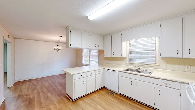 kitchen with decorative light fixtures, white cabinetry, dishwasher, sink, and kitchen peninsula