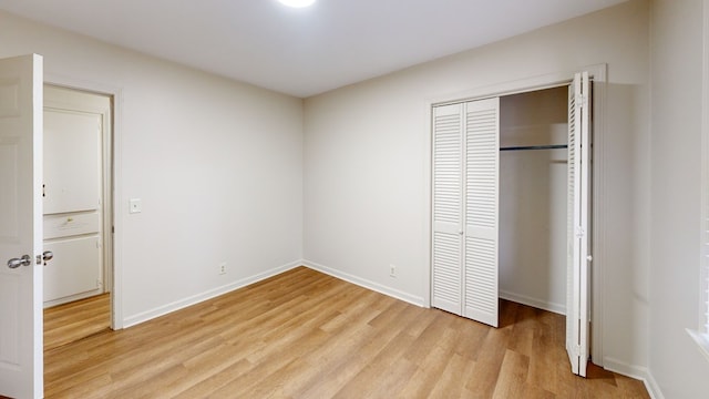 unfurnished bedroom with a closet and light wood-type flooring