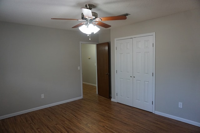 unfurnished bedroom featuring dark hardwood / wood-style flooring, ceiling fan, a closet, and a textured ceiling