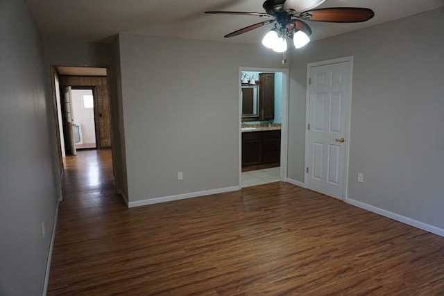 spare room featuring dark wood-type flooring and ceiling fan