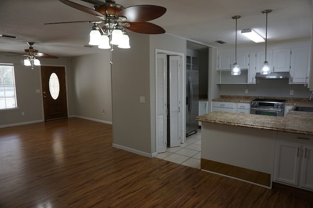 kitchen featuring appliances with stainless steel finishes, white cabinets, light wood-type flooring, and kitchen peninsula