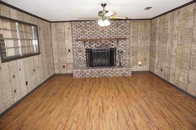 unfurnished living room with hardwood / wood-style floors, a fireplace, and ornamental molding