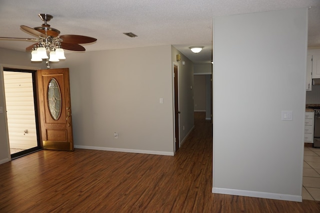 entrance foyer with ceiling fan, dark wood-type flooring, and a textured ceiling