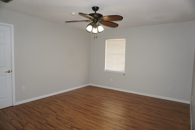 empty room featuring ceiling fan, dark wood-type flooring, and a textured ceiling