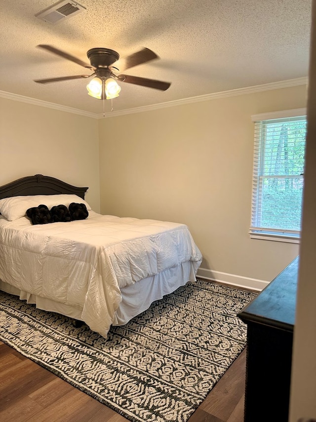 1002 Monterey Ct, Dothan, AL 36303 - bedroom featuring crown molding, wood finished floors, a textured ceiling, a ceiling fan, and baseboards