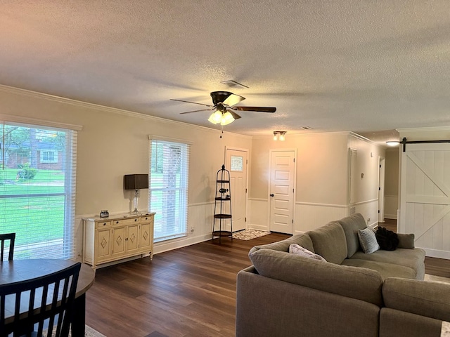 1002 Monterey Ct, Dothan, AL 36303 - living room with a barn door, a textured ceiling, dark wood-type flooring, a ceiling fan, and ornamental molding