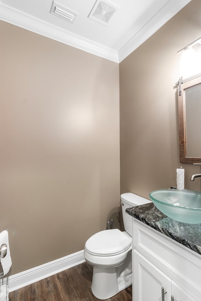 1913 W Malvern Hwy, Slocomb, AL 36375 - half bathroom with ornamental molding, wood finished floors, vanity, toilet, and baseboards