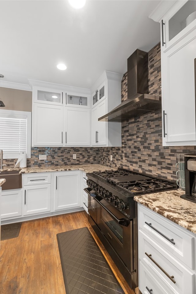 1913 W Malvern Hwy, Slocomb, AL 36375 - kitchen with wall chimney exhaust hood, double oven range, a sink, white cabinets, and tasteful backsplash