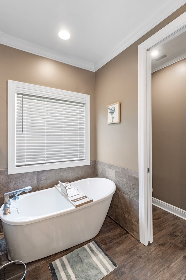 1913 W Malvern Hwy, Slocomb, AL 36375 - full bathroom featuring a freestanding tub, ornamental molding, wood finished floors, tile walls, and a wainscoted wall