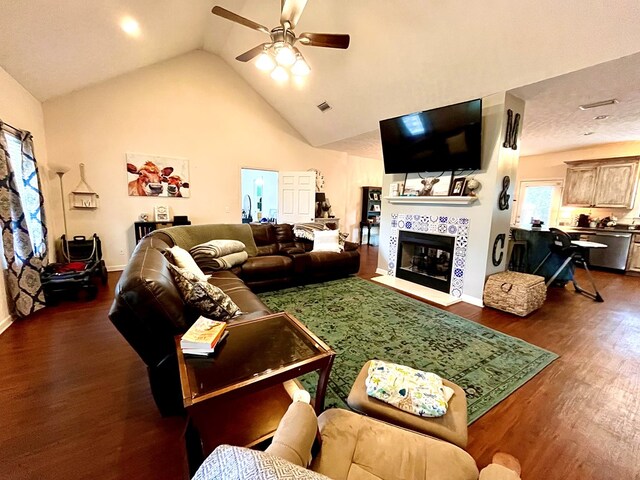 living room featuring dark hardwood / wood-style flooring, ceiling fan, a fireplace, and high vaulted ceiling