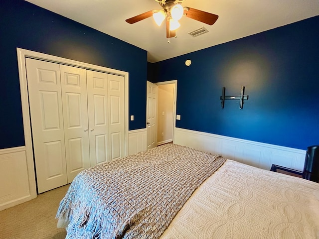 carpeted bedroom with ceiling fan and a closet