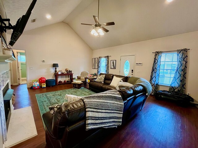 living room featuring dark hardwood / wood-style flooring, vaulted ceiling, ceiling fan, and a premium fireplace