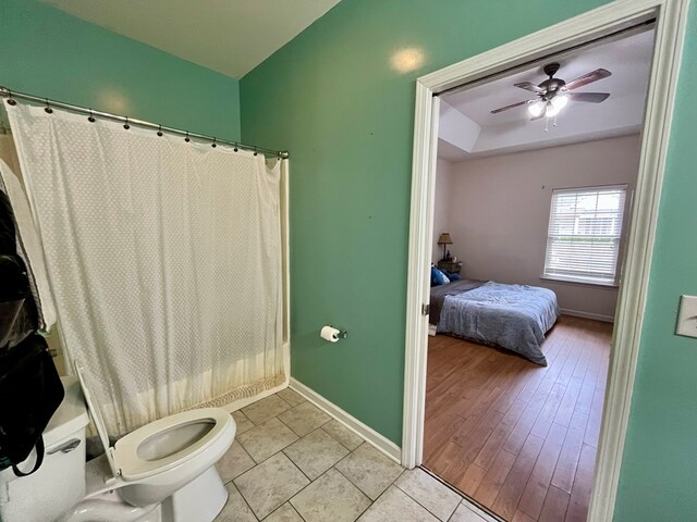 bathroom with tile patterned flooring, shower / tub combo, toilet, and ceiling fan