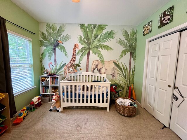 bedroom featuring a closet, carpet, and a nursery area