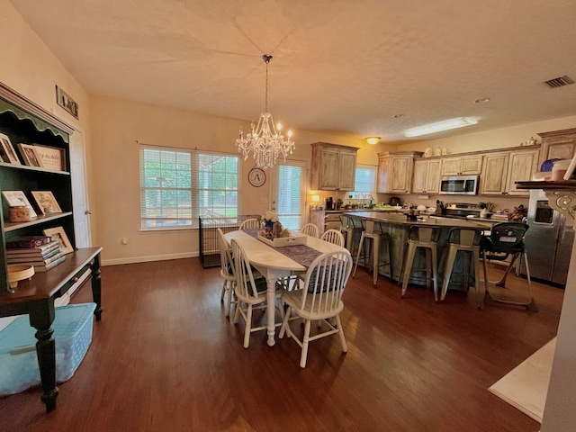 dining room featuring dark hardwood / wood-style flooring, a textured ceiling, and an inviting chandelier