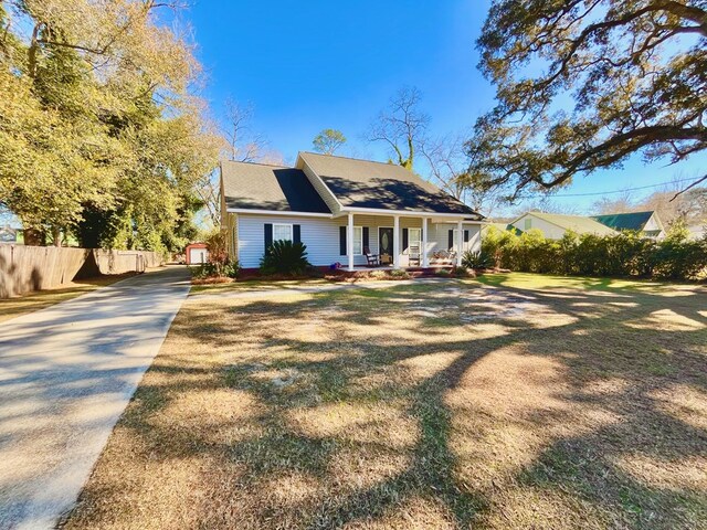 back of house featuring a lawn and covered porch