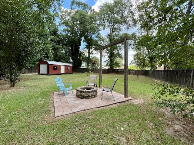 view of yard with an outbuilding, a patio, and a fire pit