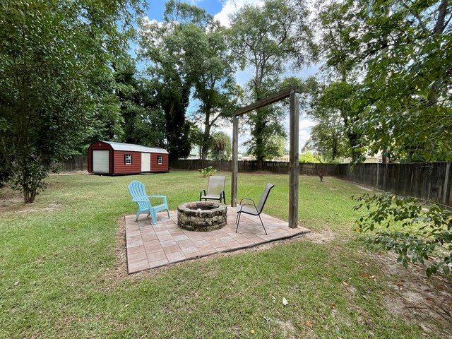 view of yard with a fire pit, an outbuilding, and a patio