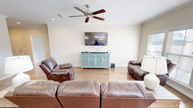 living room with crown molding, ceiling fan, a healthy amount of sunlight, and light wood-type flooring