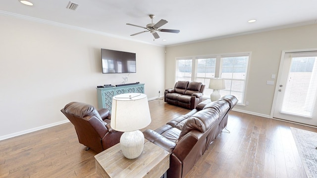 living room with crown molding, wood-type flooring, and ceiling fan