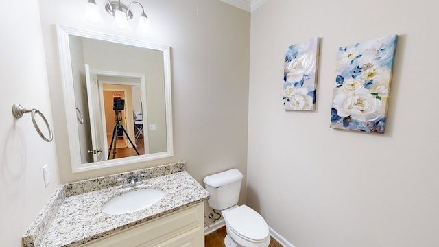 bathroom featuring vanity, ornamental molding, and toilet