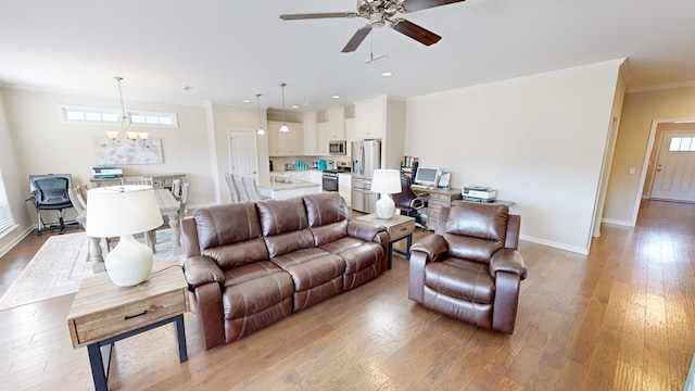 living room featuring ornamental molding, wood-type flooring, and ceiling fan with notable chandelier