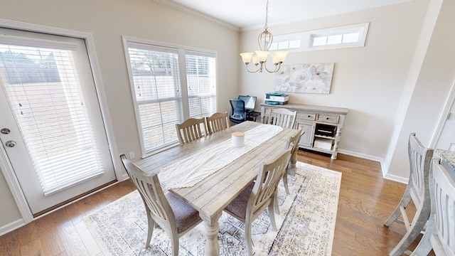 dining room featuring ornamental molding, hardwood / wood-style floors, and a notable chandelier