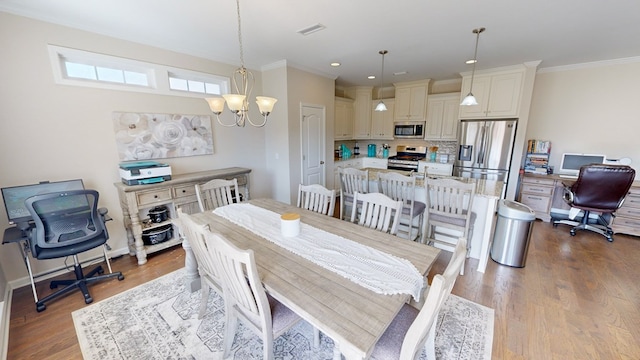 dining space with an inviting chandelier, crown molding, and light hardwood / wood-style floors