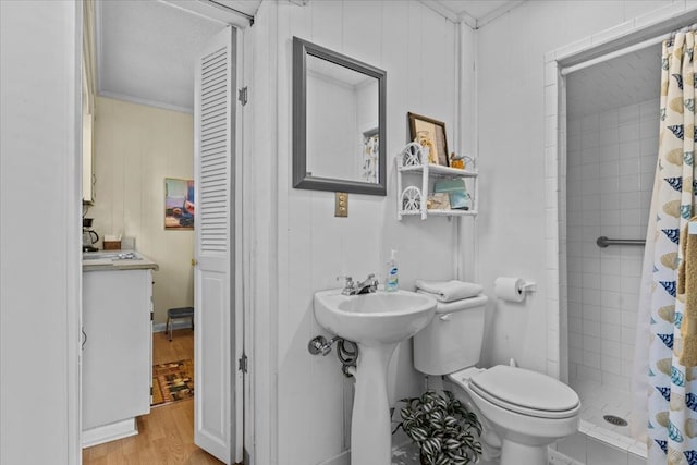 bathroom featuring a shower with shower curtain, ornamental molding, a textured ceiling, hardwood / wood-style flooring, and toilet