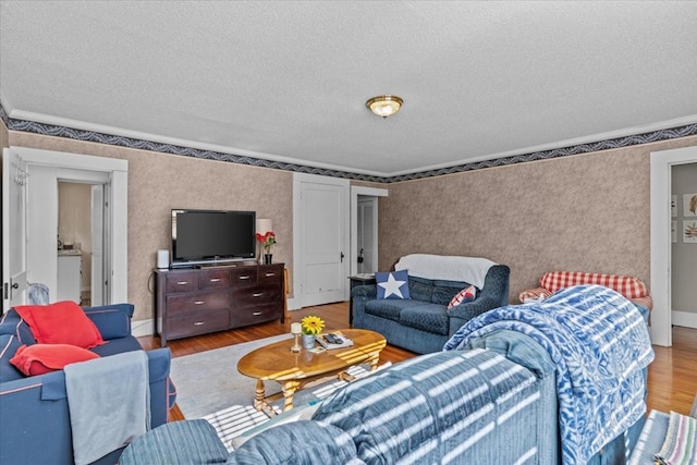 living room with a textured ceiling, hardwood / wood-style flooring, and ornamental molding