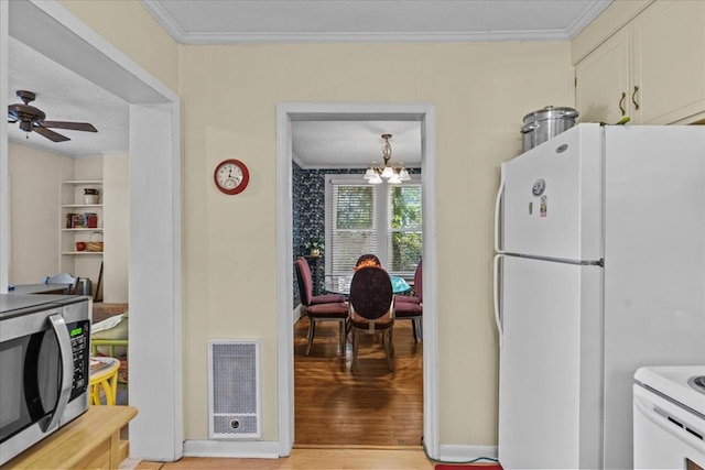 kitchen featuring a textured ceiling, ceiling fan with notable chandelier, white fridge, and crown molding